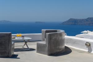 伊亚伊桑公寓及别墅 的一张桌子和椅子,坐在一个海景露台上