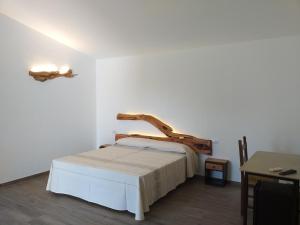 阿尔扎凯纳Turismo Rurale Lu Stazzu Arzachena的一间卧室配有一张带木制床头板的床
