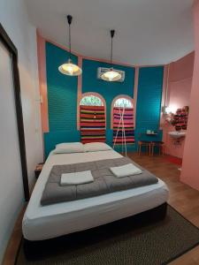坤敬Lay Day的一间卧室设有一张大床,拥有蓝色和粉红色的墙壁