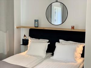 韦克舍Easy Livin' Apartment Hotel的一间卧室配有一张带白色枕头和镜子的床
