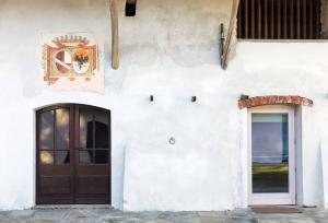 Bagnolo PiemonteAgriturismo Famiglia al Castello Di Bagnolo的白色的建筑,有门和窗户