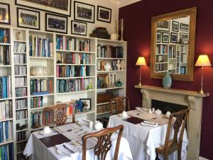 大莫尔文Ashbury Bed & Breakfast的用餐室设有2张桌子和书架