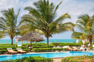 普瓦尼梅查恩加尼下一站天堂精品度假酒店的棕榈树和椅子的度假泳池和大海