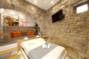 马纳罗拉Arpaiu的一间设有石墙、一张床和电视的房间