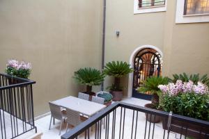 莱昂Palacete Colonial的阳台种有植物,配有桌椅