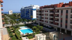 托雷德尔马尔Apartamento Atalaya Playa的享有大楼和游泳池的空中景致