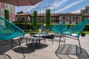 都灵B&B Hotel Torino President的庭院里摆放着几把椅子和桌子