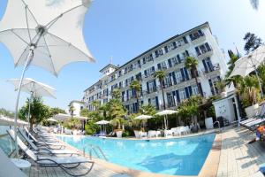 卢加诺西加藤丽都酒店的酒店设有带椅子和遮阳伞的游泳池
