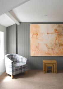 托特尼斯Hunters Lodge Inn的客厅配有沙发和墙上的绘画