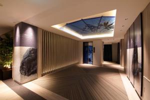 岐阜ホテル Tiger & Dragon 男塾ホテルグループ的走廊上设有天花板和玻璃窗