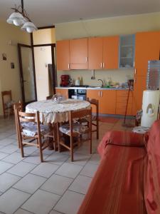 卡拉塔比亚诺Il Nido Degli Angeli的厨房配有橙色橱柜和桌椅