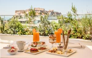 雅典雅典伊莱克特拉酒店的一张桌子,上面放着食物和一杯葡萄酒