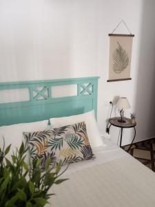 内尔哈Casa Eva - Adults Only的一张带蓝色床头板和枕头的白色床