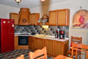 奥林匹亚达Aristoteliki- Villa的厨房配有木制橱柜和红色冰箱。