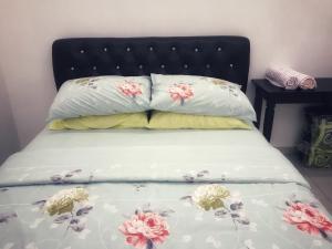 樟仑Arsyad Homestay Changlun的一张带两个枕头的床,上面有鲜花