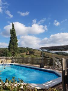 苏韦雷托Agriturismo Mezzo Poggio的蓝色的游泳池,带有木栅栏