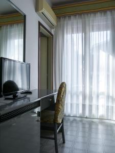 利多迪耶索罗卡萨米尔酒店的一张桌子,电视机和椅子放在房间里