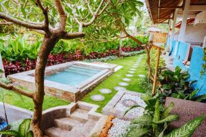 金巴兰Balangan Inn Surf Homestay的后院设有游泳池和树