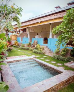 金巴兰Balangan Inn Surf Homestay的一座房子的院子内的游泳池