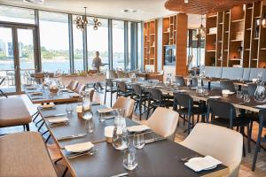 森讷堡Steigenberger Alsik – Hotel & Spa的餐厅设有桌椅和窗户。