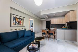雅典Olygreen Athens Residences的一间带蓝色沙发的客厅和一间厨房