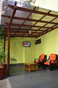 危地马拉Hotel Posada del Centro的一间设有两把椅子、一张桌子和一台电视的房间