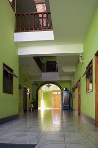 危地马拉Hotel Posada del Centro的一条带绿色墙壁和阳台的空走廊