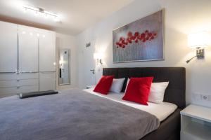 加兹尤瑟多姆Appartement "Karat" mit Penthouseflair - Oase am Haff的一间卧室配有一张带红色枕头的大床