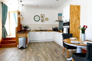 道格拉斯Welch House的厨房配有白色橱柜和木桌
