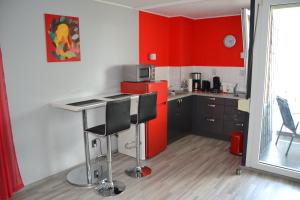 希尔德斯海姆艾姆斯坦伯格公寓的厨房配有红色橱柜和红色冰箱