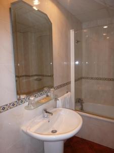 别尔萨Hostal Restaurante Asador Pañart的白色的浴室设有水槽和浴缸。