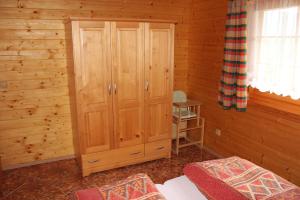 阿尔布勒茨缇策维基泽尔斯基弛霍拉次塔拉公寓及小屋酒店的小屋内一间卧室配有木制橱柜