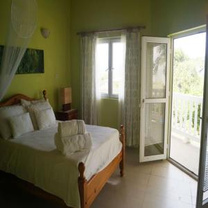 维约堡A Private Room in Paradise, Vieux Fort的一间卧室设有一张床和一个滑动玻璃门