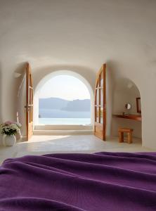 伊亚佩里奥拉斯酒店的一间卧室设有紫色的床和大窗户