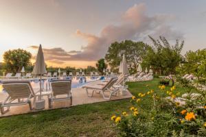 卡沃斯埃罗菲里酒店的度假村的游泳池配有椅子和遮阳伞