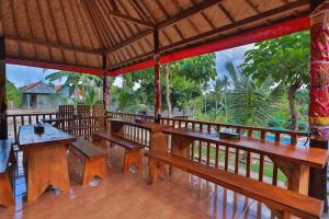 珀尼达岛Mamaras Guest House的凉亭,配有木凳、桌子和树木