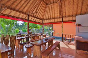 珀尼达岛Mamaras Guest House的凉亭里设有木桌和长椅的餐厅