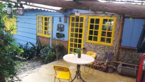 彼得罗波利斯Chales Bamboo Jungle的房屋前设有带桌椅的天井。