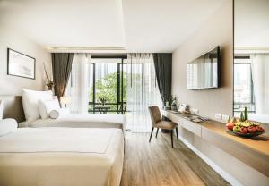 曼谷Tastoria Collection Sukhumvit - SHA Extra Plus的酒店客房配有两张床和一张书桌