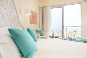 法里拉基Pegasos Deluxe Beach Hotel的一间卧室配有一张带蓝色枕头的床