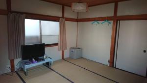 田边市熊野宾馆的一间配有电视的房间和一张桌子