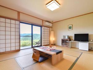 田边市Kirinosato Takahara的客厅设有大窗户和电视。
