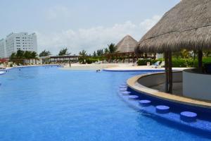 坎昆Cancun Amara的一个带草伞的大型游泳池
