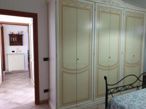奥里亚case vacanze, La casa di Angelo, con terrazzo的一间卧室,卧室旁边设有大型绿色橱柜