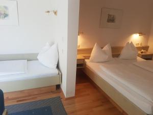 巴德加斯坦Comfort Rooms Bruckner的配有白色枕头的客房内的两张床