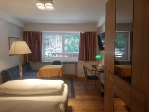 巴德加斯坦Comfort Rooms Bruckner的酒店客房设有两张床和一张桌子。