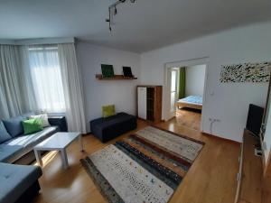 维也纳Haus Apricum - schön wohnen & gratis parken的客厅配有蓝色的沙发和地毯。