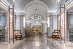罗马马尔蒂斯宫殿酒店的大楼内带椅子和讲台的大堂