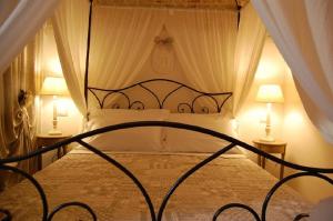 阿尔贝罗贝洛La Cantina的一间卧室配有一张带两盏灯的天蓬床。