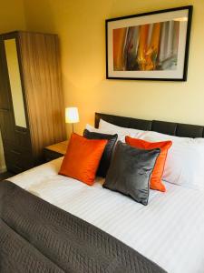 埃普瑟姆AmberBlue@Epsom的一间卧室配有橙色和灰色枕头。